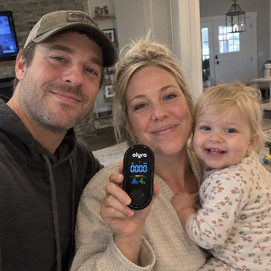 A couple with a toddler holding the TrueDetect detector at home.